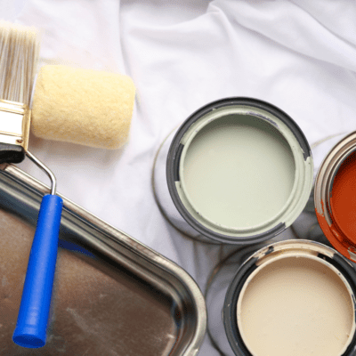 preparation for a home painting project with green, cream, and red color paint.