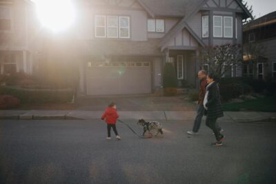 family and dog walking down a residential street