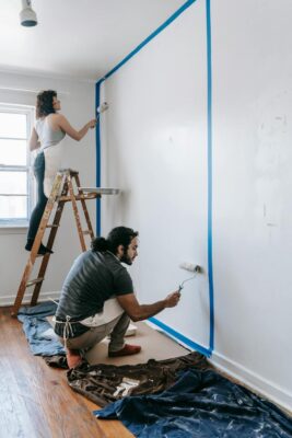 couple painting a wall white